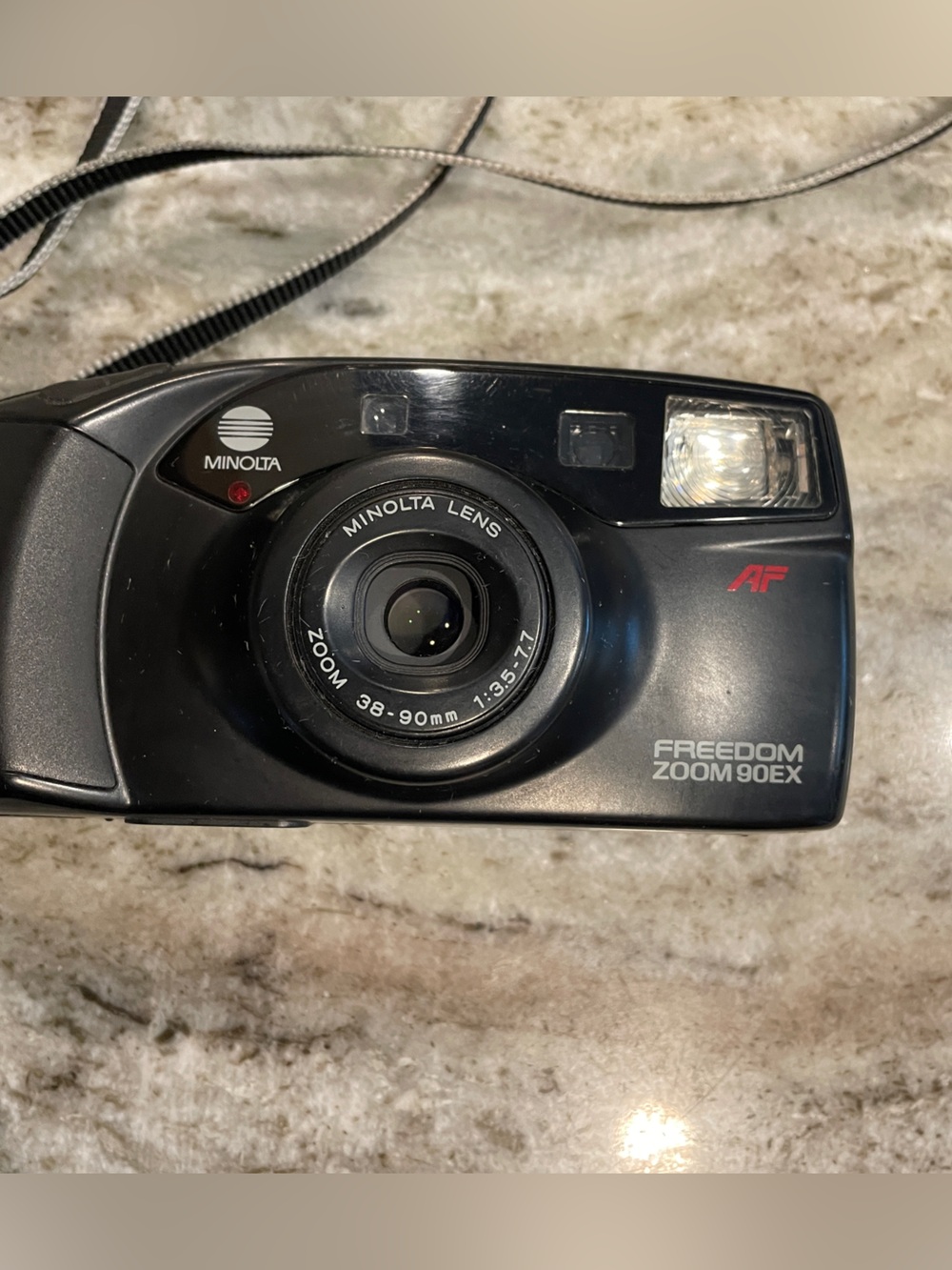 This is a Minolta Freedom Zoom 90EX 35mm point-and-shoot film camera with strap